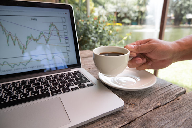 trader-man-hand-holding-a-cup-of-black-coffee-and-analysis-tactical-move-strategy-analysis-of-stock t20 1Qamxx