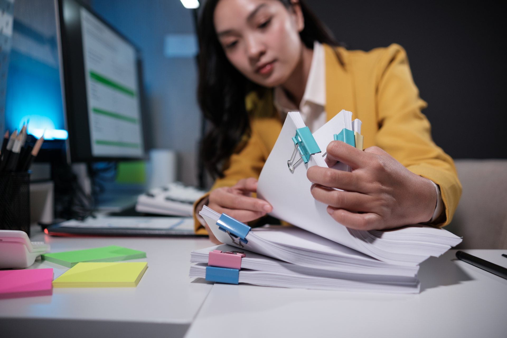 vrouw kantoor bladert door stapel papieren