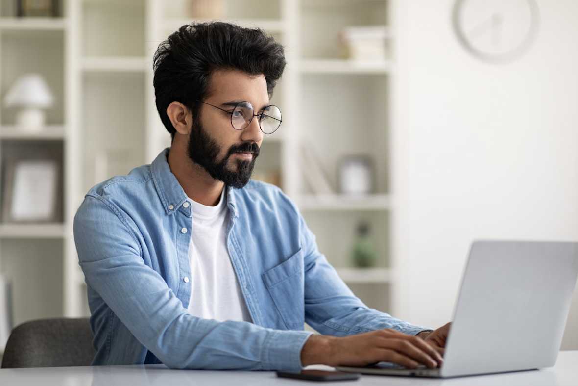 Man aan het werk achter laptop, aan de slag met het opstellen van een functieprofiel