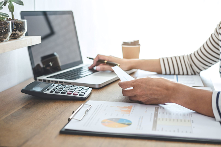 vrouwmetlaptopenrekenmachine