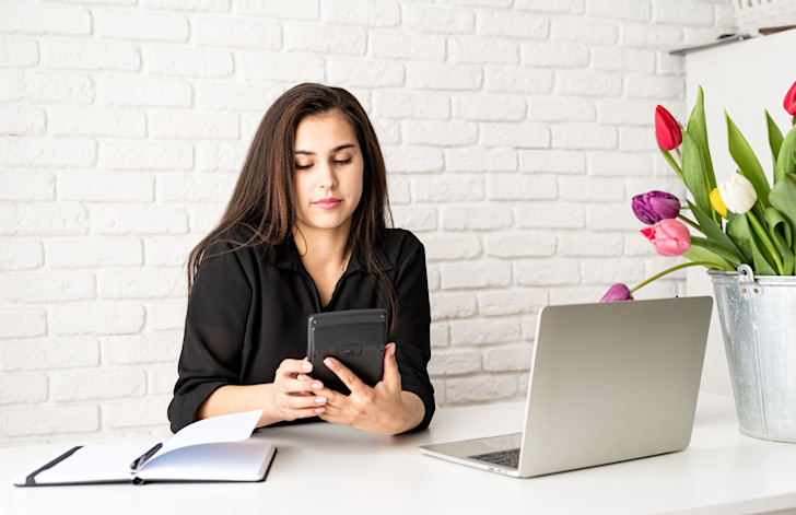 Jonge zakenvrouw aan het werk rekenmachine laptop