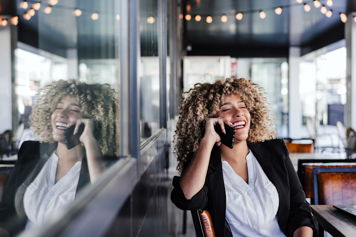 vrouw-krullen-telefoon-cafe-buiten-bellen-ondernemer-zzp