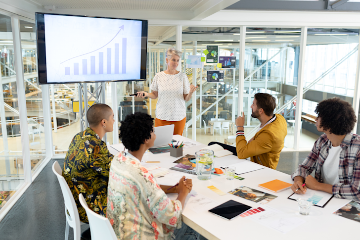 Vrouw presenteert aan divers team met stijgende lijn omhoog