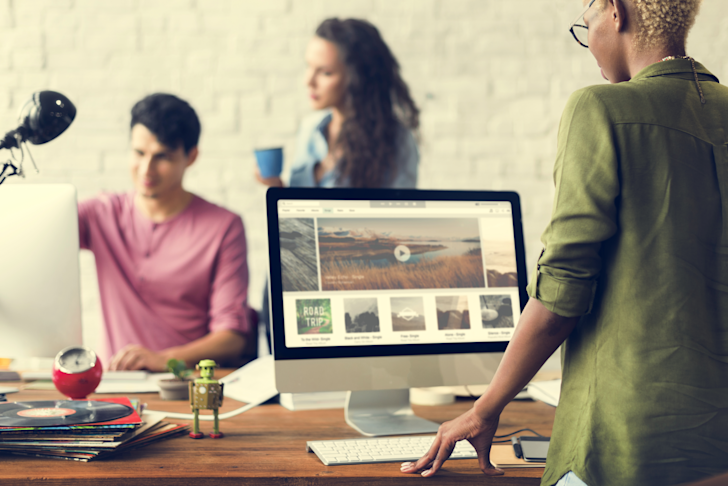 Computer op bureau met mensen eromheen - Website hosting provider