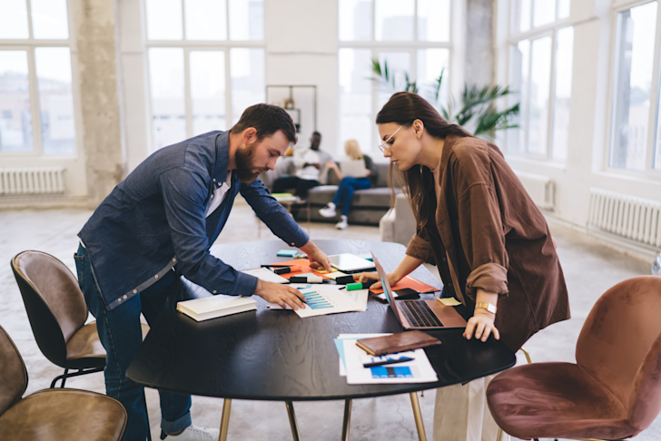 Man en vrouw aan het werk aan een tafel in een kantoor