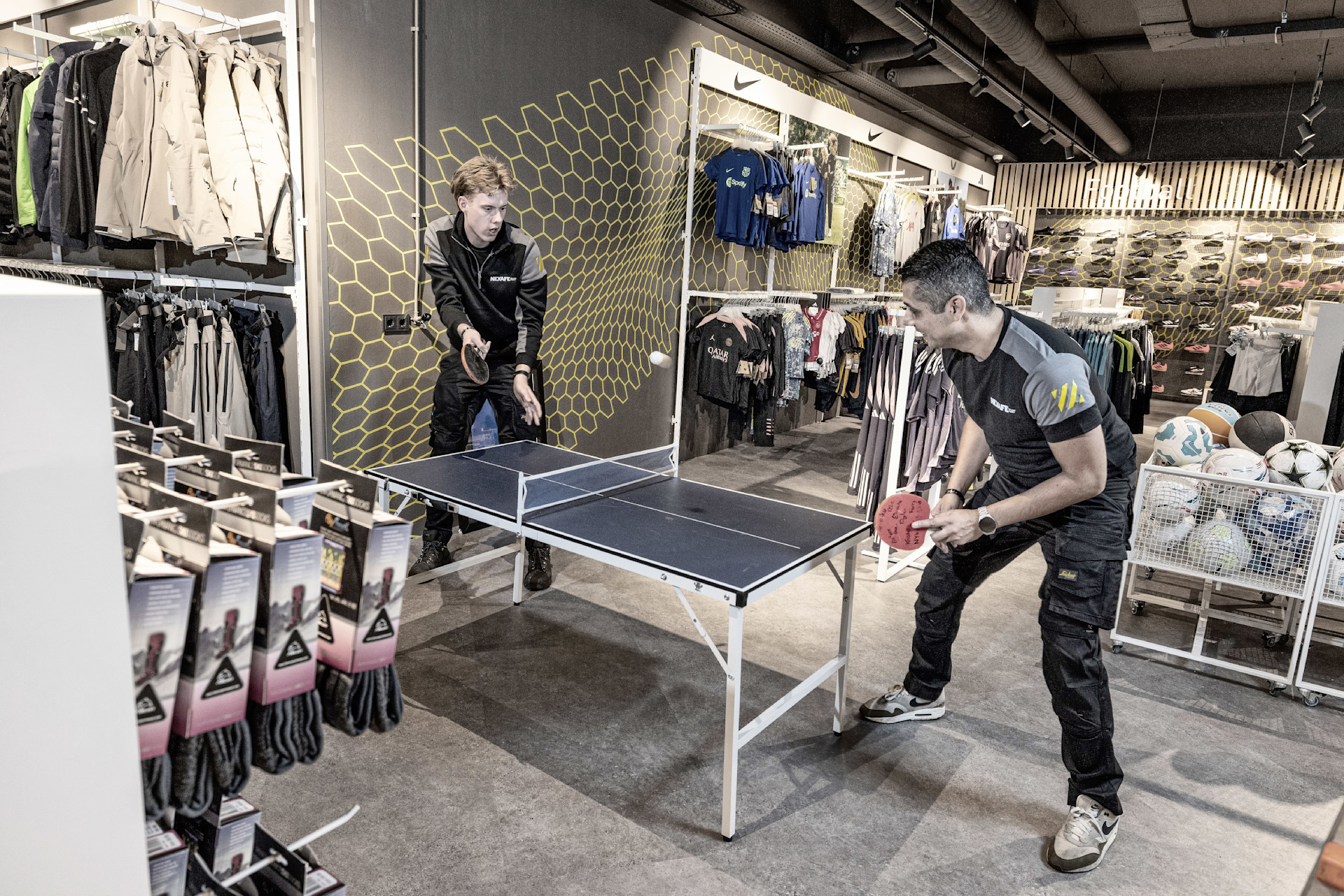 NEXAFE medewerkers pingpongen even tijdens een klus in een sportzaak